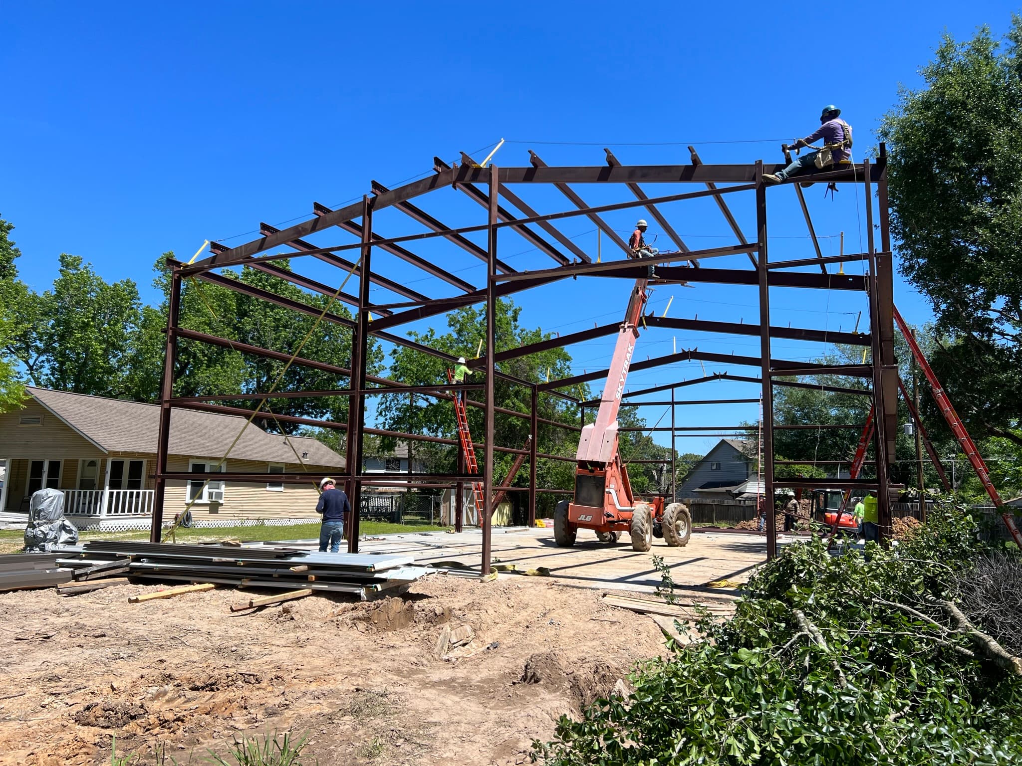 Steel frame of a barndominium under construction against an open Texas sky