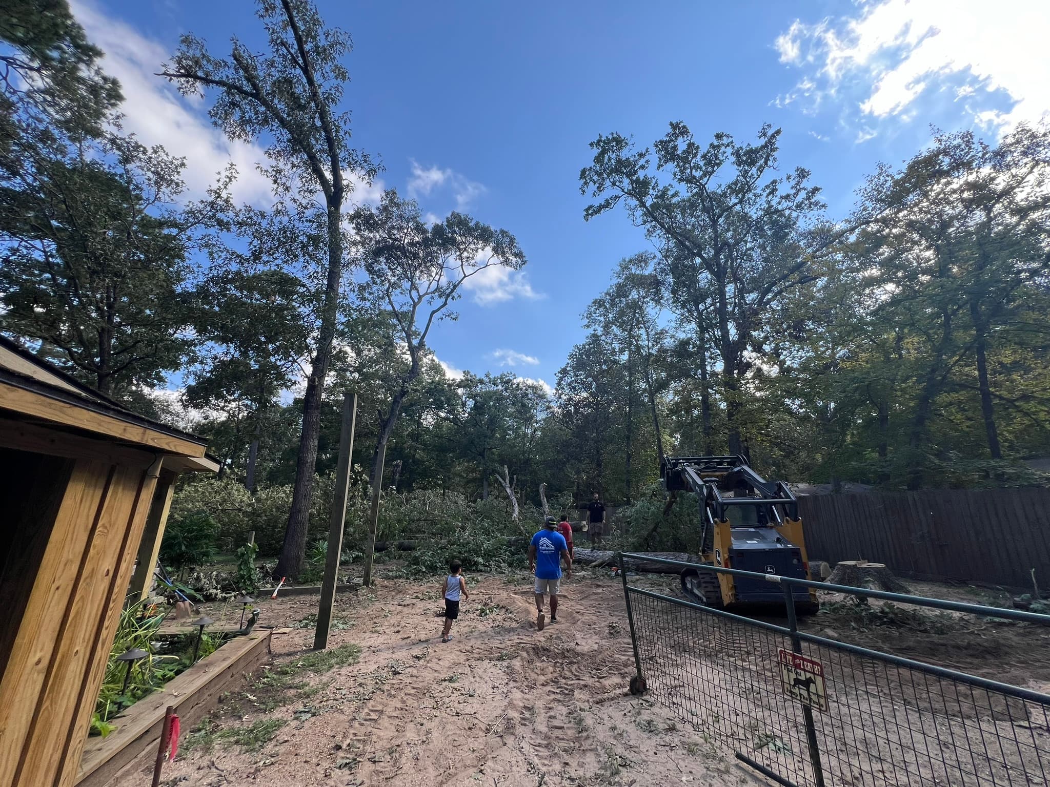 The Roofing 365 crew clearing storm-downed trees on a Montgomery County property